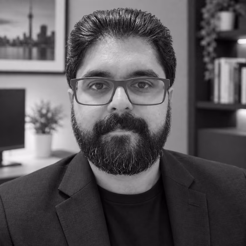 Humza Tariq wearing glasses and a dark blazer